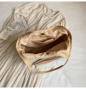 Internal view of straw tote bag with rainbow stripes, lining, and magnetic closure