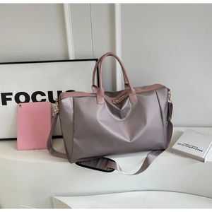Détail du grand sac de voyage montrant son tissu imperméable lisse et ses anses solides
