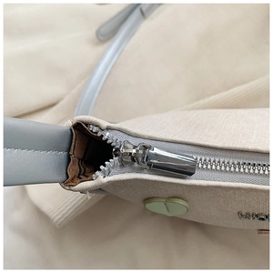 Close-up of premium silver zipper and textured cross-grain leather on the beige bag