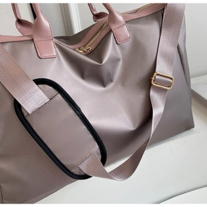 Détail du grand sac de voyage violet en nylon avec bandoulière réglable amovible