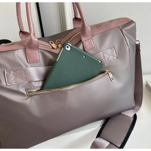 Détail du sac de voyage avec poche avant pour tablette et poignées en cuir