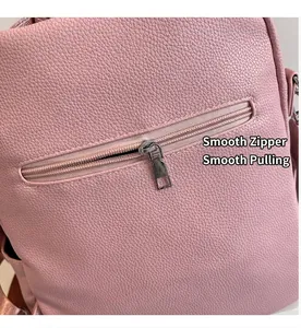 Détail de la texture cuir rose grainé et de la fermeture éclair en métal du sac à dos