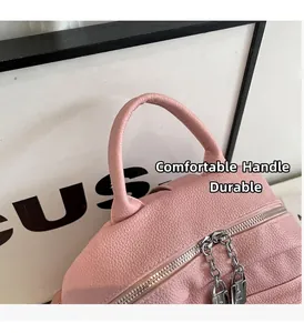 Détail du sac à dos en cuir rose avec double fermeture éclair argentée et texture