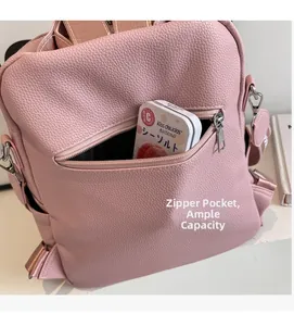 Détail de la poche zippée avant sur un sac à dos en cuir rose avec capacité de rangement