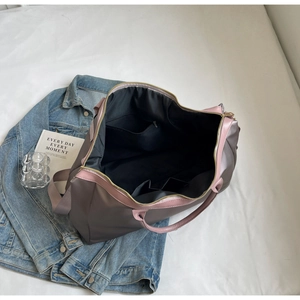 Vue détaillée de l'intérieur du sac de voyage avec compartiments et anses roses