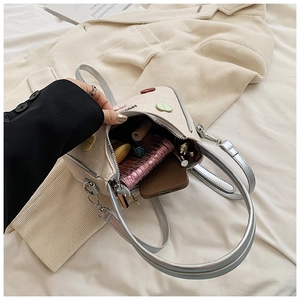 Detail of off-white crossbody bag interior showing space for phone and wallet