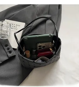 Vue de dessus d'un grand sac en toile gris foncé perforé montrant un intérieur spacieux