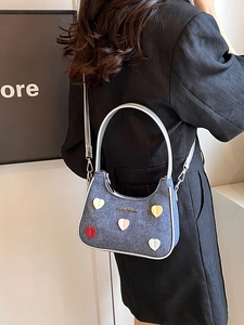 Blue denim crossbody bag with colorful heart patches and silver metallic top handle