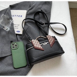 Top view of black lychee leather handbag with a silk scarf handle and golden zipper