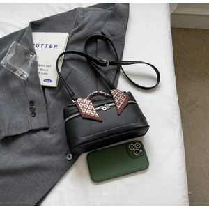 Detailed shot of black lychee grain box bag with silk scarf on handle and silver zipper