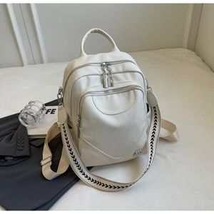 Détail du sac à dos en cuir beige avec bandoulière large à motifs géométriques noirs