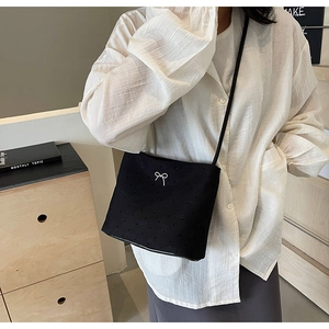 Détail du sac bandoulière noir à pois avec noeud argenté et longue bandoulière fine