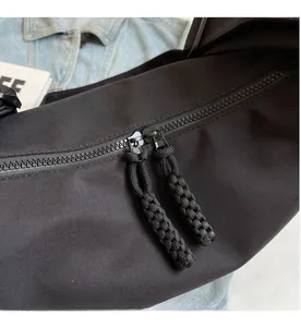 Détail de la double fermeture éclair fluide et des cordons sur le sac en nylon noir