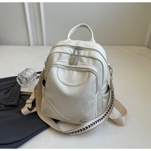 Détail d'un sac à dos blanc en cuir grainé avec bandoulière tissée et plusieurs zips