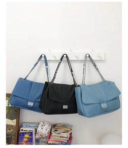 Trois grands cabas en jean avec chaîne argentée en bleu foncé, noir et bleu clair
