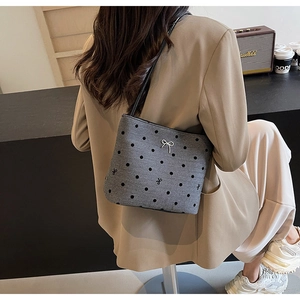 Détail du cabas gris à pois avec nœud argenté et fine bandoulière en cuir noir