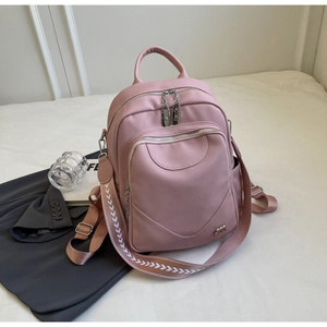 Vue détaillée du sac à dos en cuir rose clair avec texture grainée et logo métal