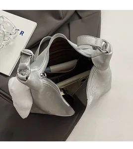 Interior view of silver dumpling bag showing phone compartment and striped lining