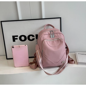 Sac à dos rose en cuir synthétique avec poche zippée et bandoulière tissée à motif en V