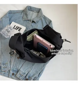 Vue détaillée du sac bandoulière en nylon noir montrant sa grande capacité de rangement