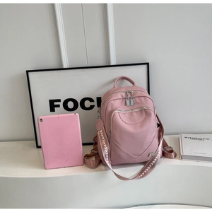 Vue détaillée du sac à dos en cuir rose avec bretelles tissées et logo M en métal