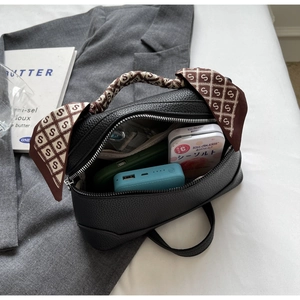 Interior view of black pebbled leather tote bag with silk scarf handle and storage capacity