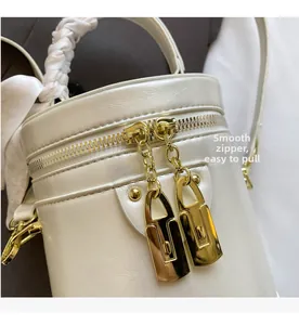 Detailed macro view of white textured bucket bag featuring smooth gold lock-shaped zippers