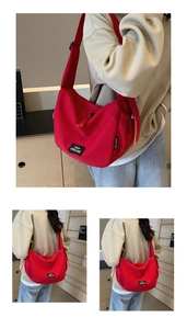 Détail du grand sac bandoulière en toile rouge avec une large sangle confortable