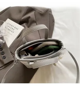Internal view of the light grey bucket bag showing spacious compartments and zip pocket