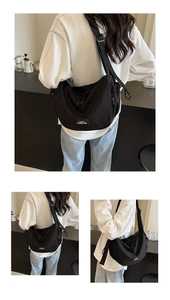 Détail du sac bandoulière en toile noire avec sangle réglable et finitions logo