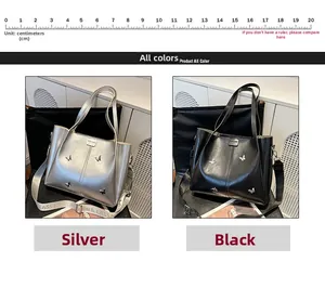 Detail of silver and black tote bag featuring butterfly metal accents and wide crossbody strap