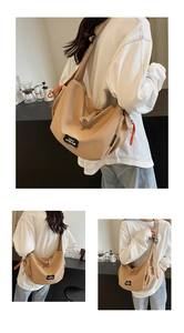 Détail du sac bandoulière croissant kaki avec tirette orange et patch de logo