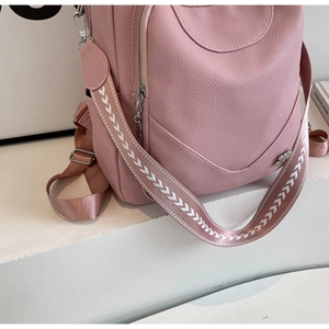 Détail de la texture cuir rose litchi et bandoulière tissée jacquard du sac à dos chic