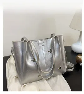 Macro view of silver tote bag featuring 3D metal butterfly ornaments and wrinkled texture