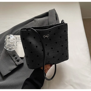Détail du sac en toile à pois avec motif chevrons et ornement de nœud en métal argenté