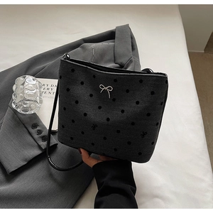 Détail du sac seau en toile à chevrons avec pois noirs et nœud argenté élégant