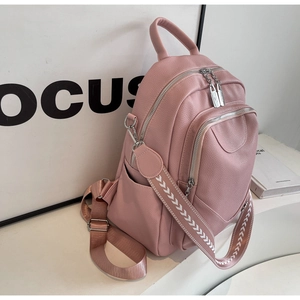 Détail du sac à dos en cuir souple rose clair avec grain litchi et sangle tissée