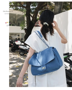 Vue lifestyle d'un sac en jean avec chaîne et fermoir argenté porté par un modèle