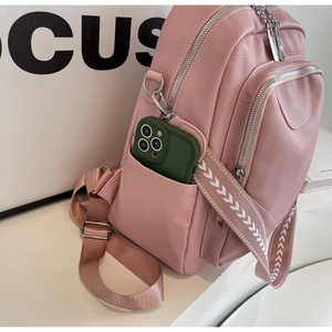 Détail du sac à dos en cuir rose avec poche latérale et bandoulière à motifs