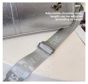 Close-up of adjustable gray nylon strap with metal buckle for silver tote bag