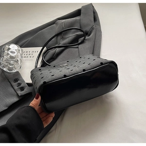 Détail du sac en tweed gris à pois noirs floqués et ornement de nœud métallique