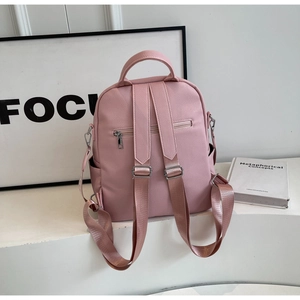 Détail du sac à dos en cuir rose avec texture litchi et bretelles réglables