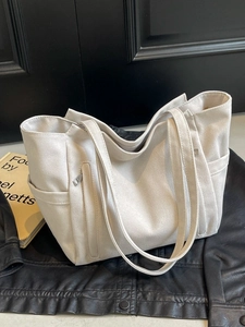 Minimalist canvas tote bag with large capacity for women featuring side pockets in ivory