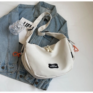 Gros plan sur le sac besace en nylon crème avec cordon orange et logo sportif en relief