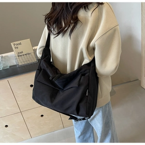 Detailed view of the large black crossbody bag side label and durable nylon fabric