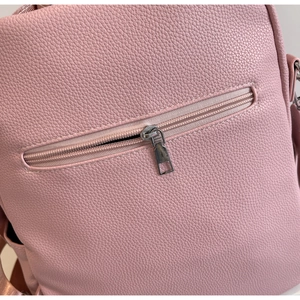 Détail de la texture cuir PU grainé et fermeture éclair argentée sur sac rose