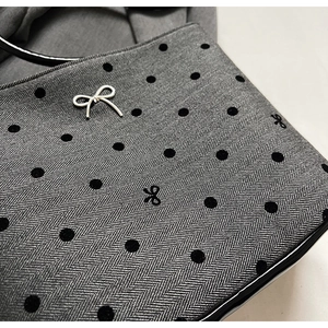 Détail du sac en toile chevron avec pois floqués et ornement de nœud argenté