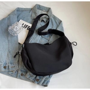Détail du sac croissant en nylon noir avec bandoulière réglable et tirette tressée