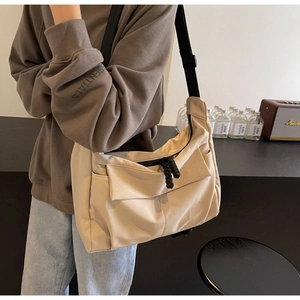 Detail of canvas crossbody bag with wide strap and thick rope zipper puller