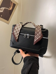 Elegant black lychee leather crossbody handbag with decorative silk scarf on the handle